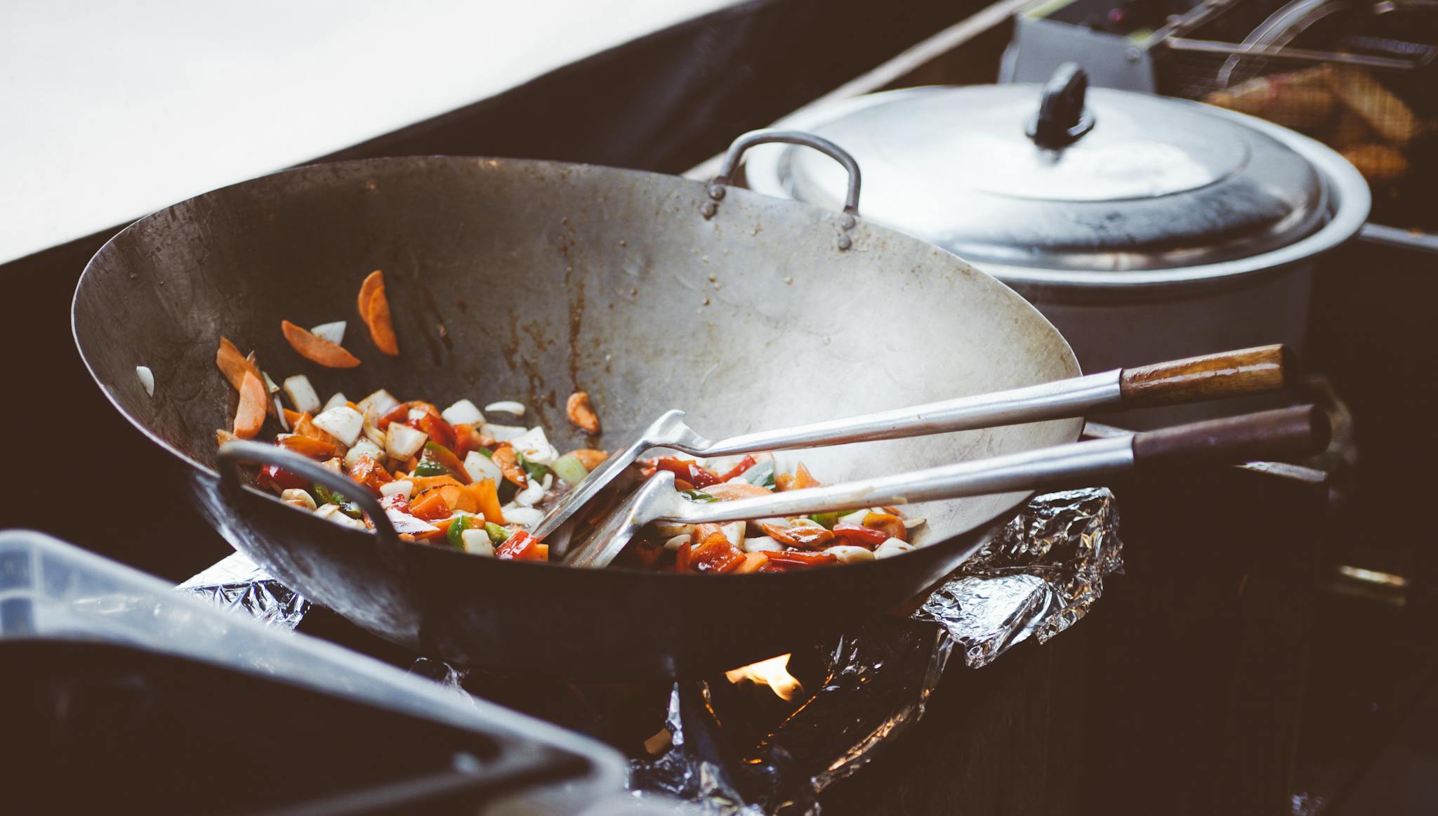Colorful stir-fry vegetables cooking in a wok on a stovetop. Perfect for healthy meal inspiration.