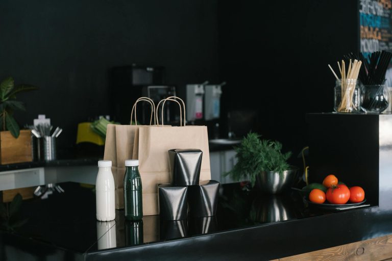 Eco-friendly takeaway packaging in a modern kitchen setting with fresh ingredients and cutlery.