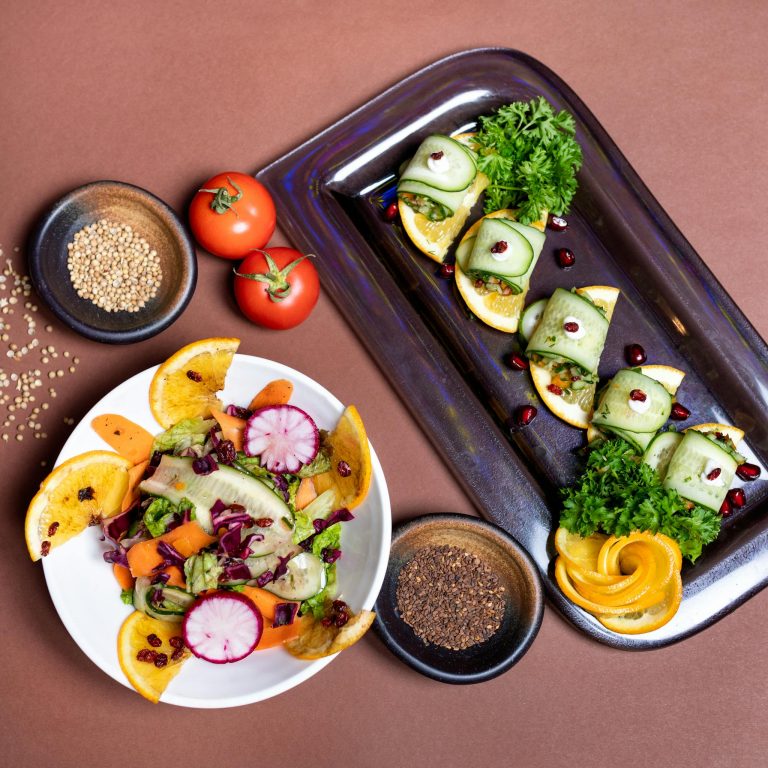 Top view of a colorful vegetarian salad and appetizer platter with fresh vegetables and garnishes.